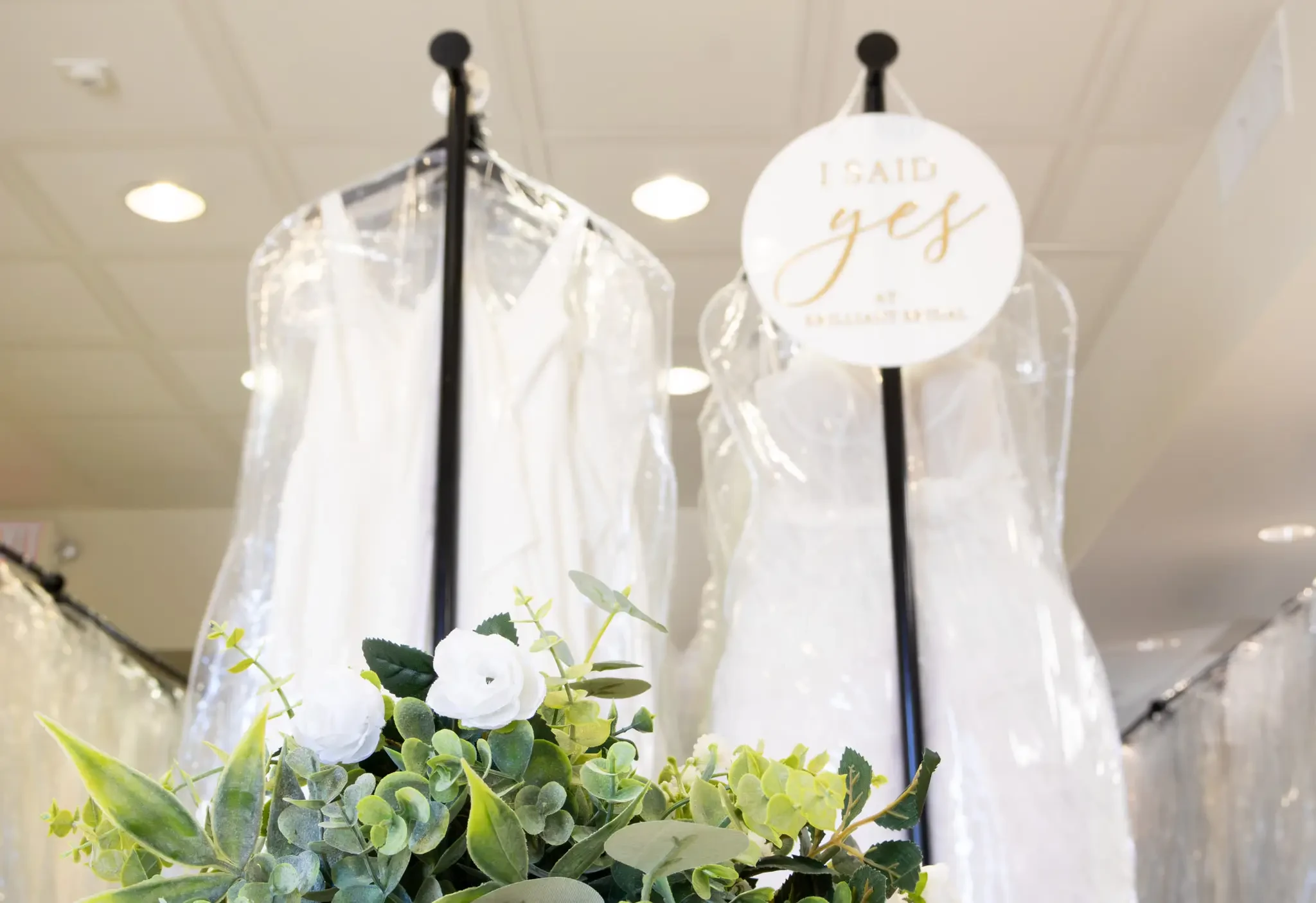 Image of racks full of designer wedding dresses with a said yes to the dress sign hanging